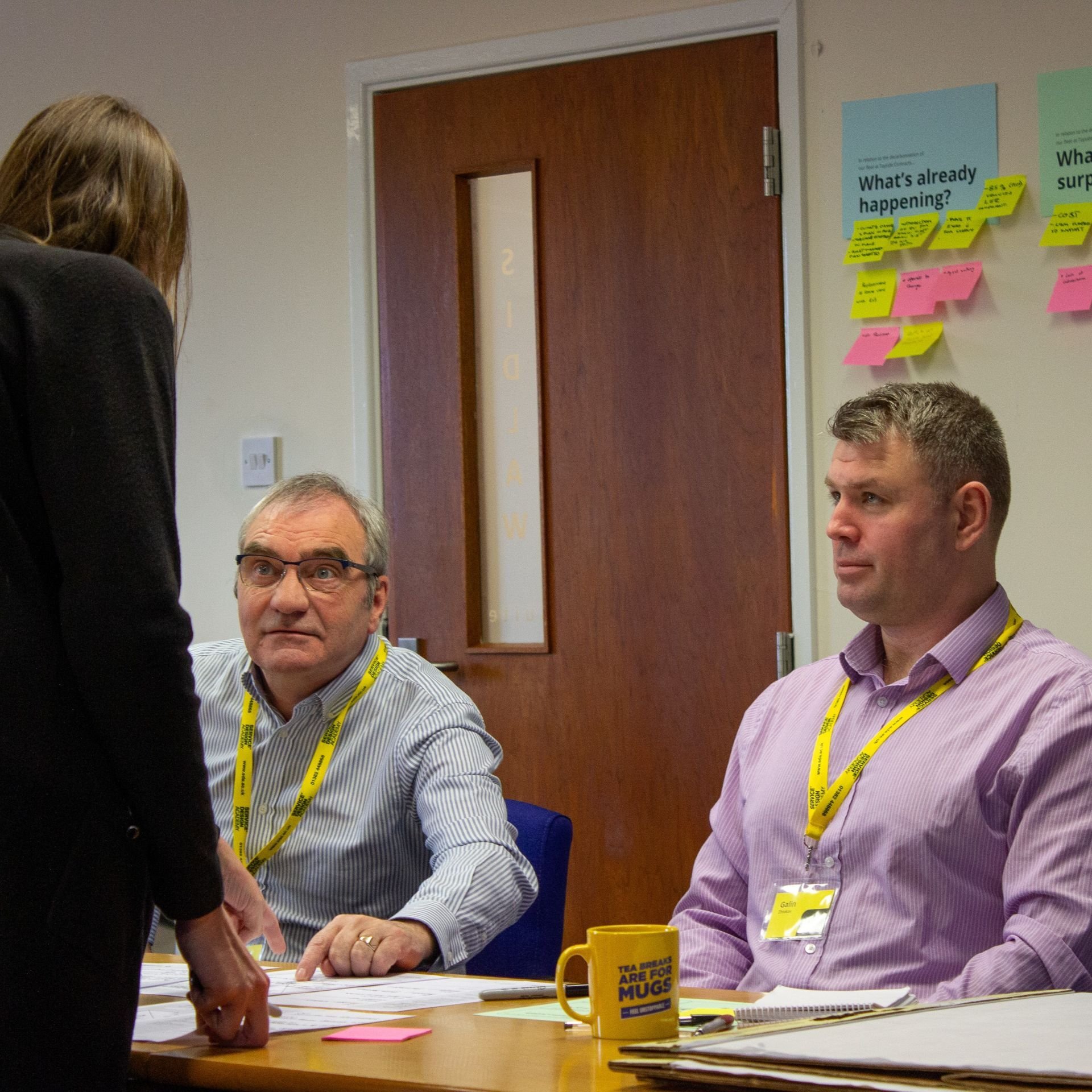 Two students from Tayside Contracts having a group discussion around a table.