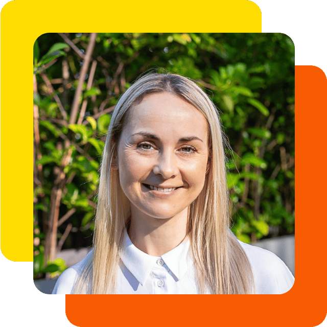 Jo is a middle-aged white woman with long and straight blonde hair. She's pictured here smiling and wearing a white blouse.